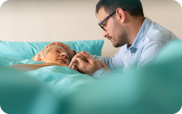 Clinician speaking with a patient resting in bed.