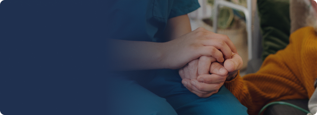 Two people holding hands in a compassionate, reassuring gesture.